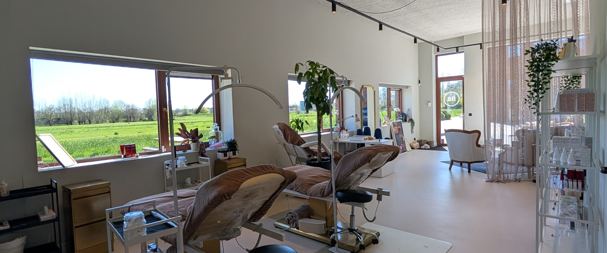 Lichte en rustgevende beautysalon van Super Natural Beauty met comfortabele behandelstoelen en uitzicht op het groen.